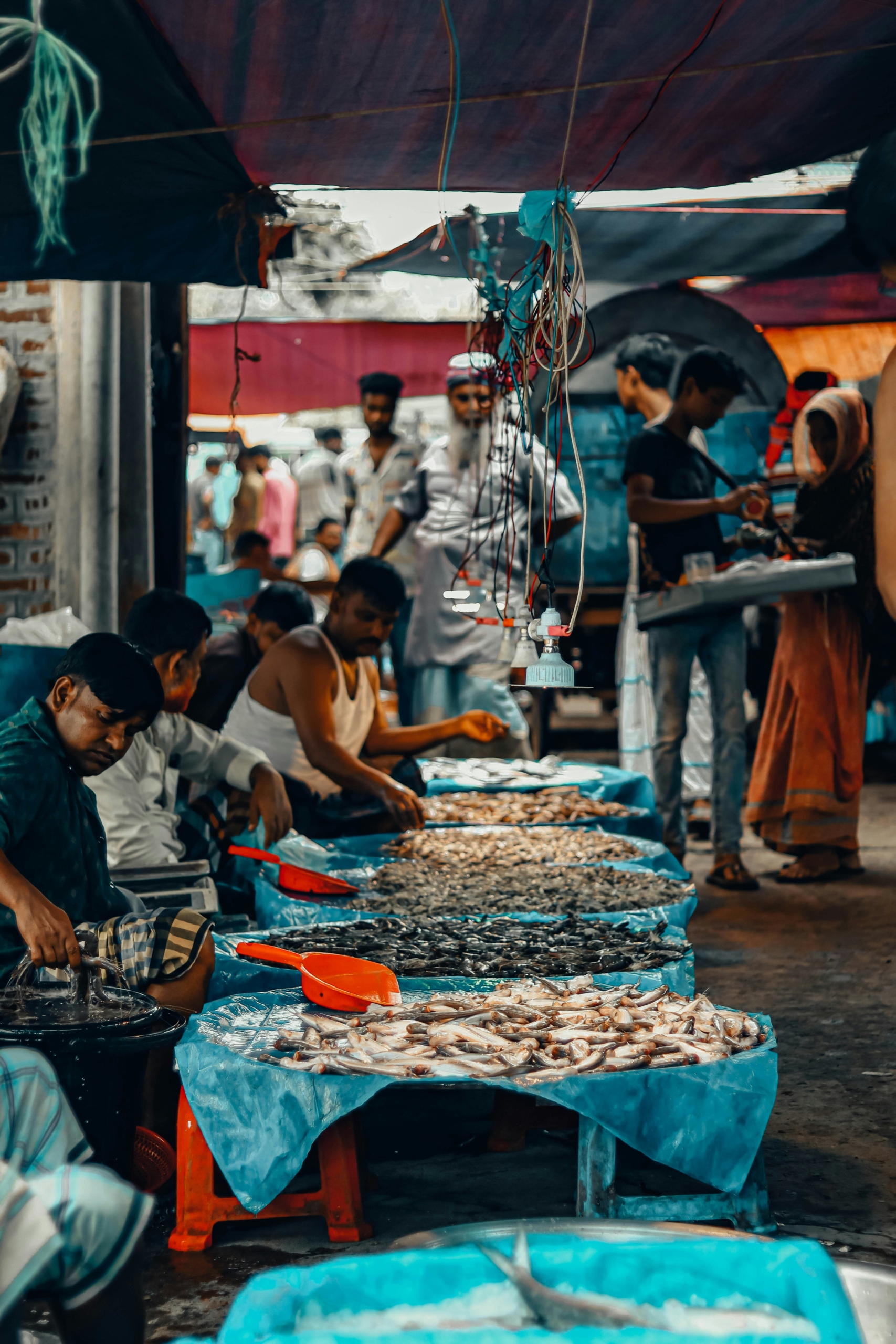 a group of people standing around a table filled with food